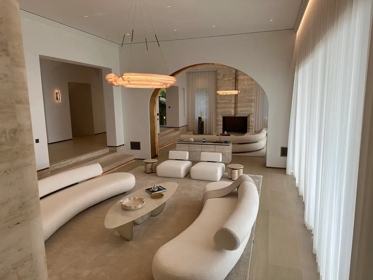 Custom luxury living room with sculptural seating and arched architectural details